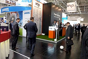 INP team and customers play soccer next to INP booth